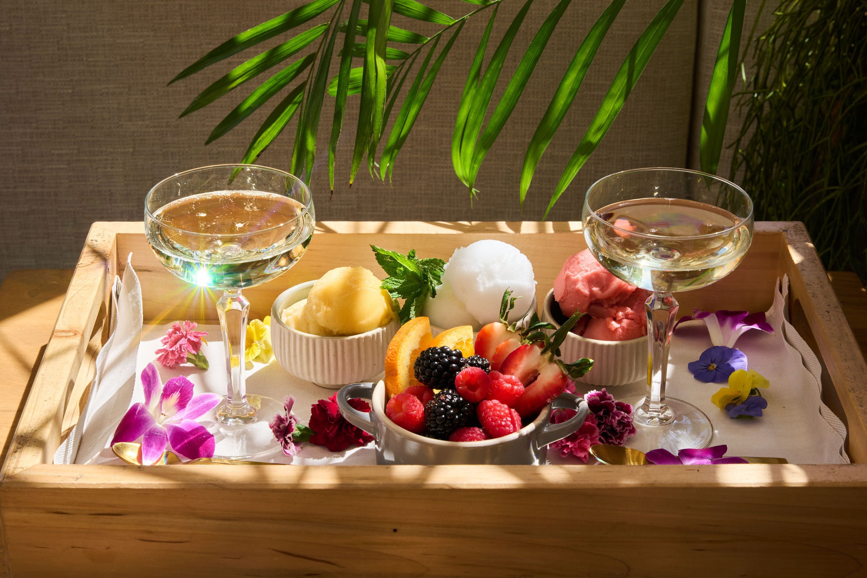 Refreshing cocktails served with fruit sorbets and fresh berries on a wooden tray at Casa Madera West Hollywood.
