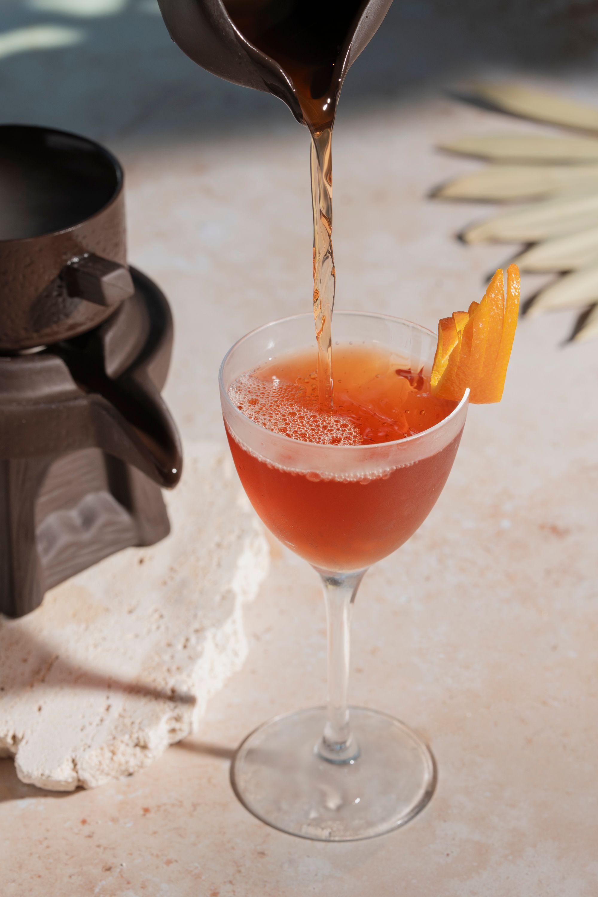 A cocktail is being poured into a glass garnished with orange slices at Casa Madera West Hollywood cocktail restaurant.